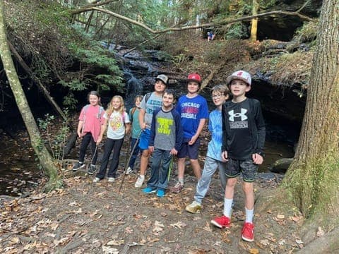 Kids hiking by a waterfall