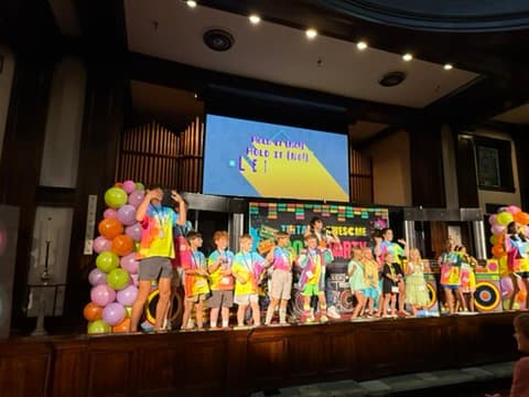 Kids and youth on stage with balloons and organ pipes